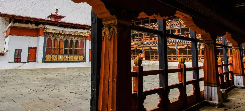 Traditional Bhutanese monastery courtyard in Paro with ornate wooden architecture and colorful painted details