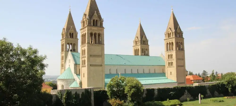 Pécs Cathedral with distinctive twin towers and green copper roof showcasing Hungarian Romanesque architecture