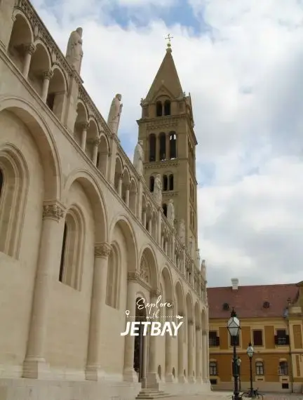 Romanesque cathedral facade with ornate arches and bell tower in historic Pecs, Hungary destination