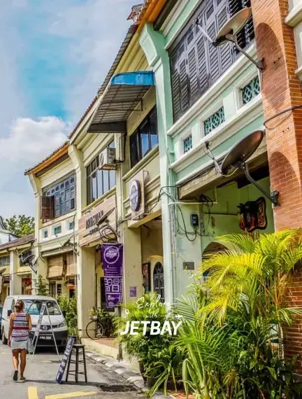 Colorful colonial shophouses with traditional architecture line a bustling street in George Town, Penang