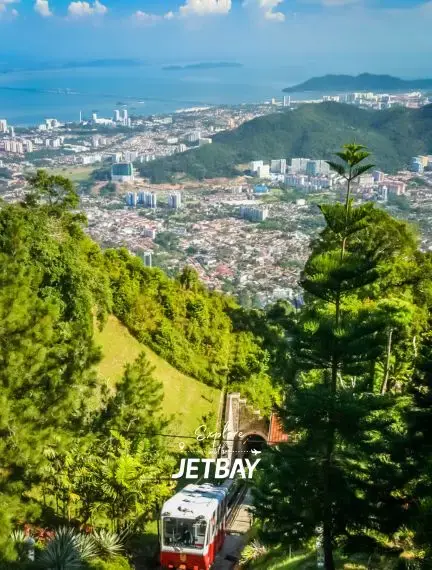 Penang Hill funicular railway ascending through lush tropical forest with panoramic city and coastline views