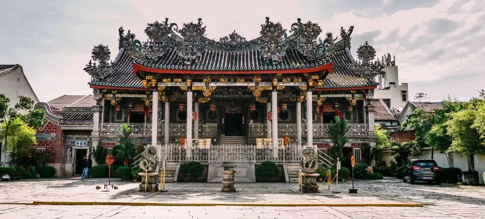 Traditional Chinese temple with ornate roof decorations and columns in historic Penang, Malaysia