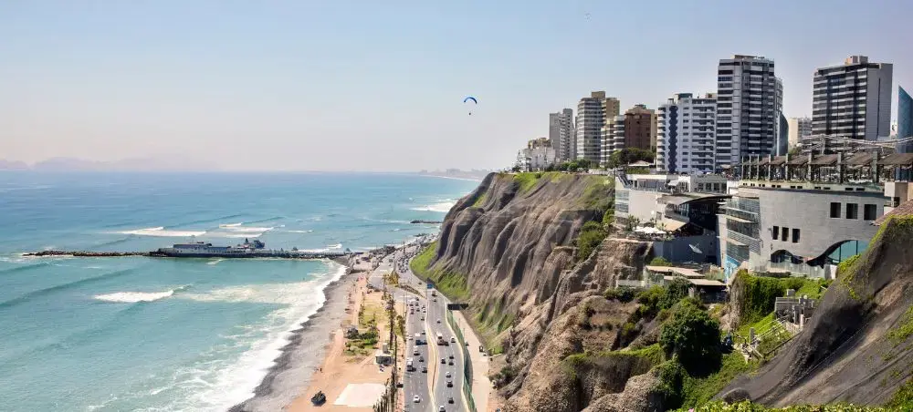 Coastal Lima skyline with modern buildings overlooking Pacific Ocean beaches and dramatic cliffs in Peru