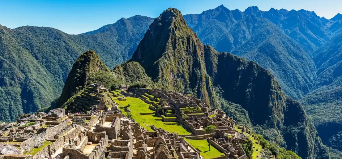 Machu Picchu ancient citadel perched on mountain ridge surrounded by dramatic Andes peaks in Peru