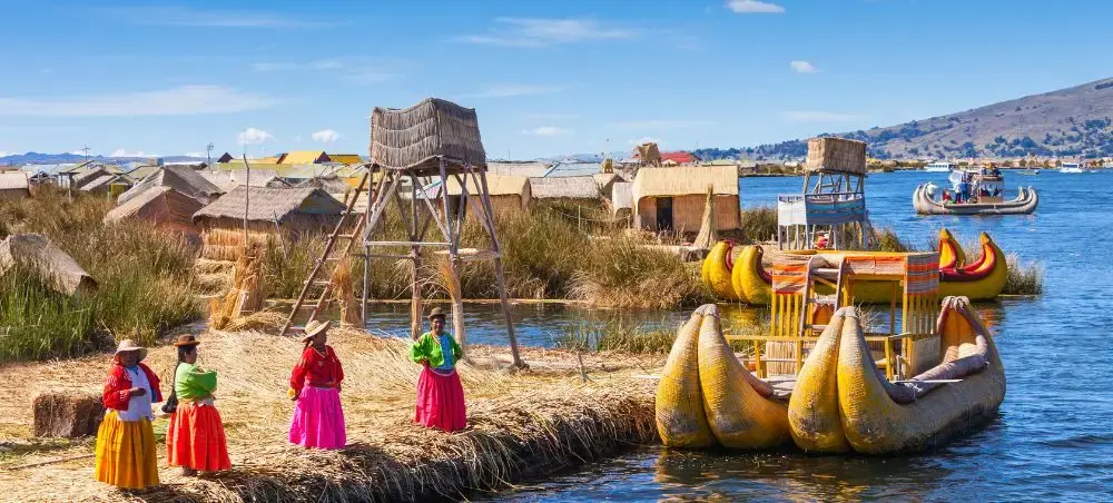 Traditional Uros floating islands on Lake Titicaca with reed boats and colorful local residents in Peru