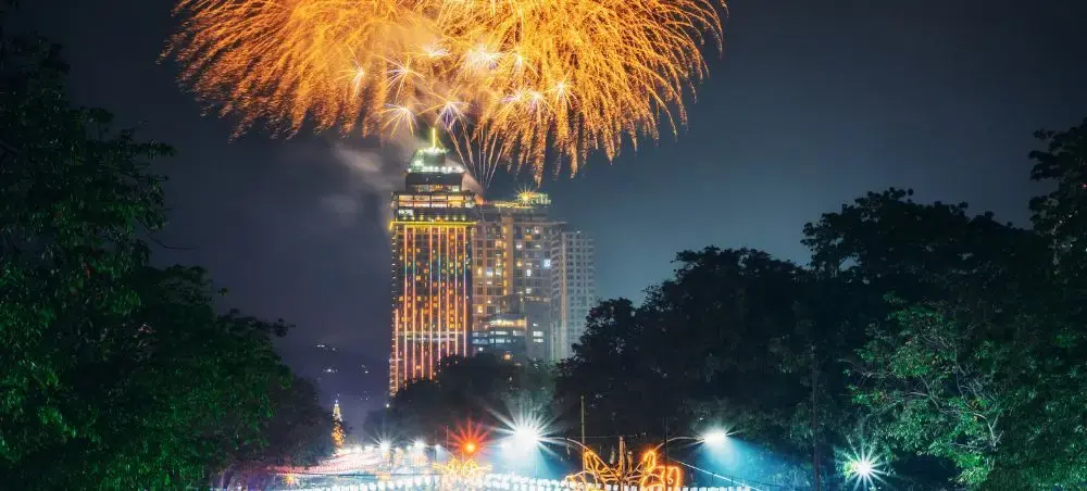 Spectacular fireworks display illuminating luxury hotel towers in Philippines during festive celebration