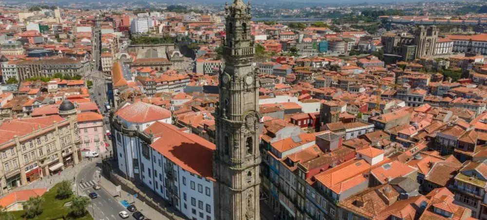 Aerial view of Porto's historic center showcasing iconic Clérigos Tower and traditional terracotta rooftops