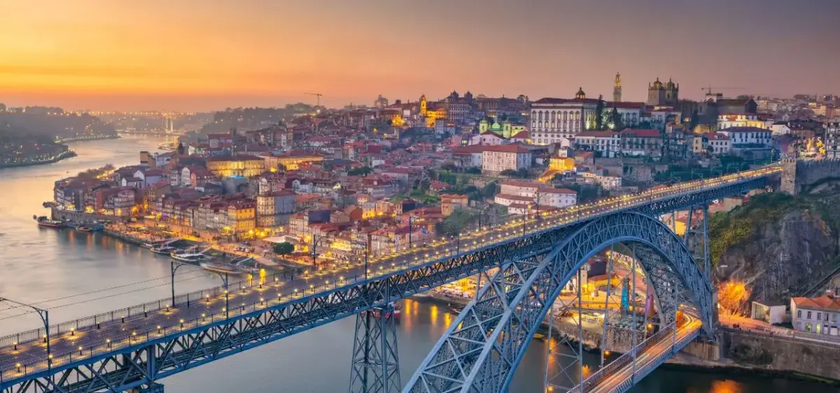 Porto's historic cityscape illuminated at sunset with Dom Luís I Bridge spanning the Douro River