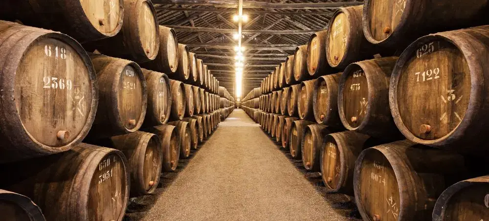Traditional wine cellar with aged port barrels in Porto, showcasing Portugal's renowned fortified wine heritage