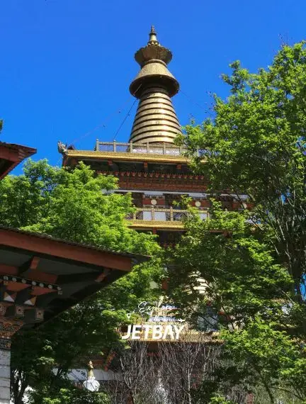 Traditional Bhutanese pagoda temple with ornate wooden architecture surrounded by lush greenery in Punakha