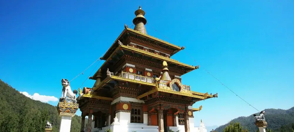 Traditional Bhutanese temple with ornate golden details and multi-tiered architecture in Punakha valley