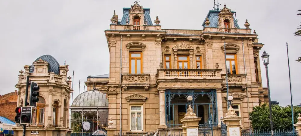 Historic colonial architecture with ornate stone facades and blue rooftops in downtown Punta Arenas, Chile