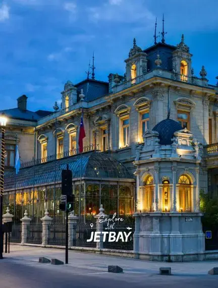 Historic neoclassical building illuminated at twilight in Punta Arenas showcasing elegant architecture