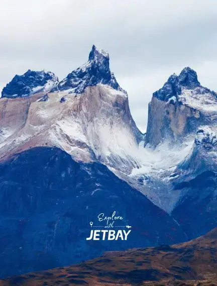 Dramatic snow-capped granite peaks of Torres del Paine rising above Patagonian landscape near Punta Arenas