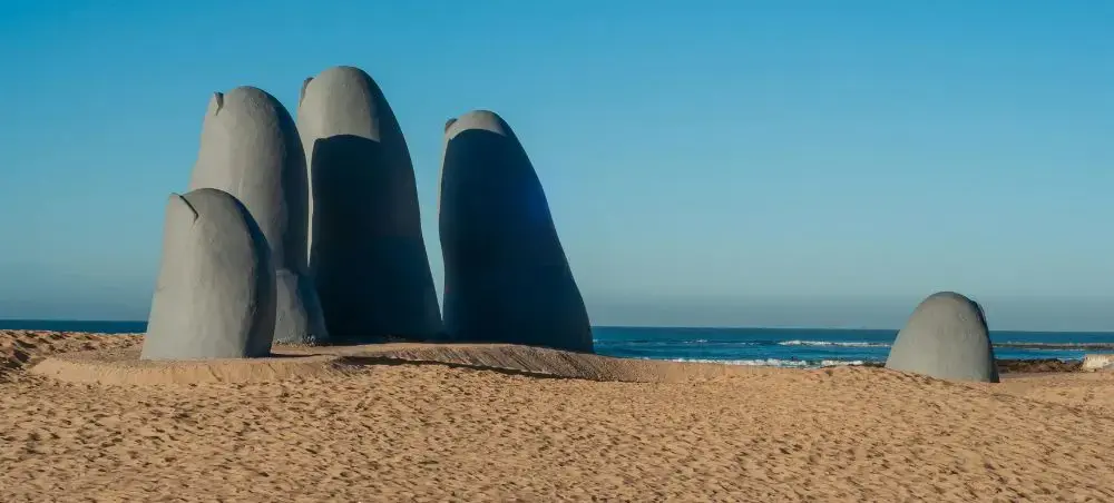 Famous Hand sculpture emerging from Brava Beach sand in Punta del Este, Uruguay's premier resort destination