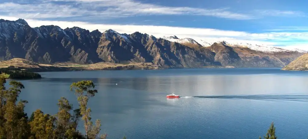 Pristine Lake Wakatipu surrounded by snow-capped mountains near Queenstown, New Zealand's premier destination