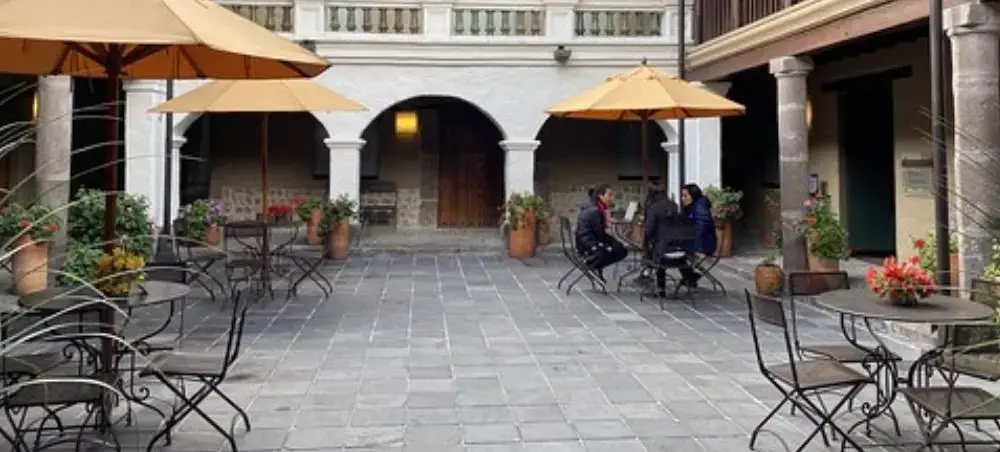 Elegant colonial courtyard restaurant in Quito's historic center with outdoor dining tables and umbrellas
