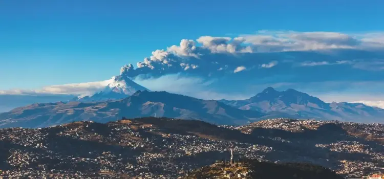 Dramatic volcanic peaks and urban sprawl of Quito Ecuador showcasing Andean mountain ranges under blue sky