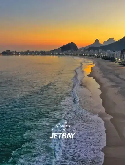 Copacabana Beach at golden hour sunset with iconic Sugarloaf Mountain silhouette and Rio coastline