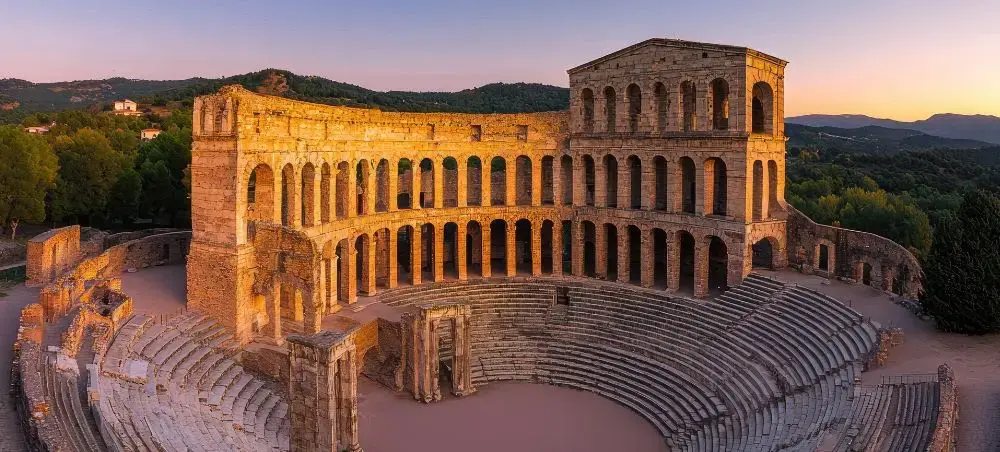 Ancient Roman amphitheater bathed in golden sunset light showcasing Italy's historic architecture