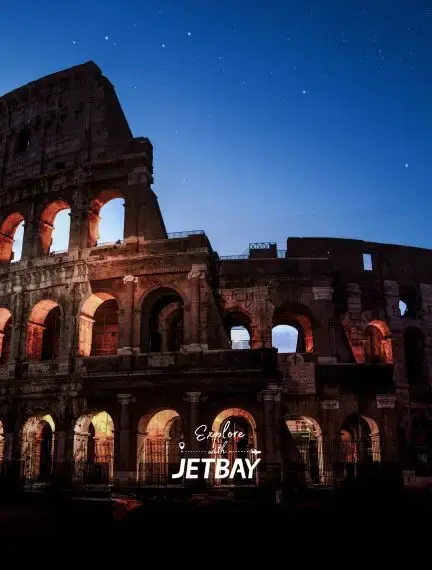 Ancient Colosseum illuminated at twilight under starry sky showcasing Rome's historic grandeur for luxury travelers