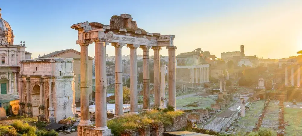 Ancient Roman Forum ruins bathed in golden sunset light showcasing Rome's timeless heritage and luxury travel appeal