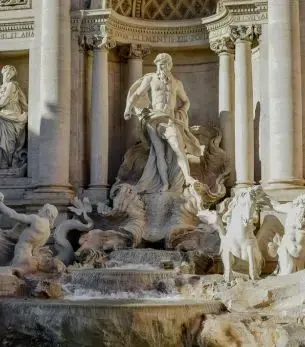 Trevi Fountain's majestic Neptune statue surrounded by ornate baroque architecture in Rome Italy