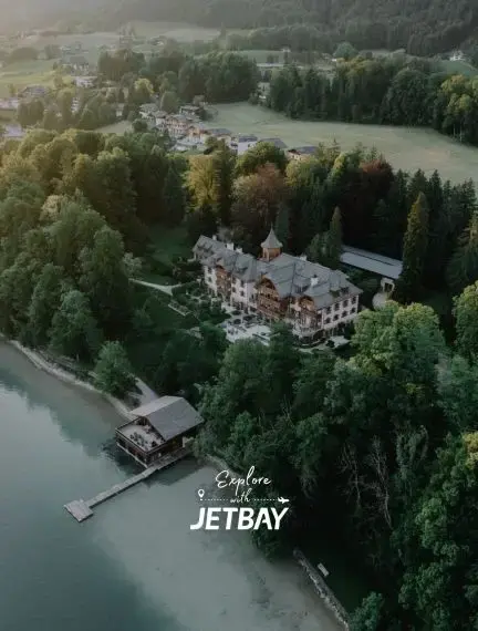 Aerial view of luxury lakeside resort nestled in Austrian Alps forest near Salzburg destination