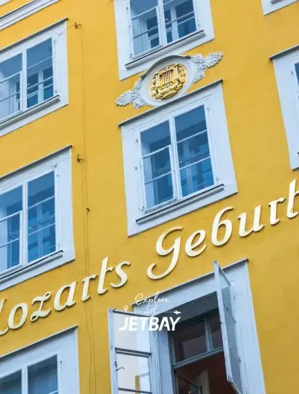 Historic yellow baroque building in Salzburg's old town featuring traditional Austrian architecture and Mozart's birthplace