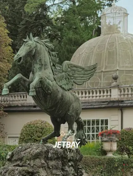 Pegasus statue with bronze wings stands majestically before historic Salzburg palace architecture