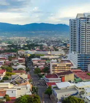 San José Costa Rica cityscape with modern high-rise buildings and mountain backdrop for luxury travel