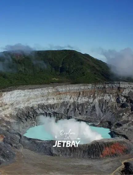 Volcanic crater lake with turquoise waters surrounded by lush Costa Rican mountains and misty clouds
