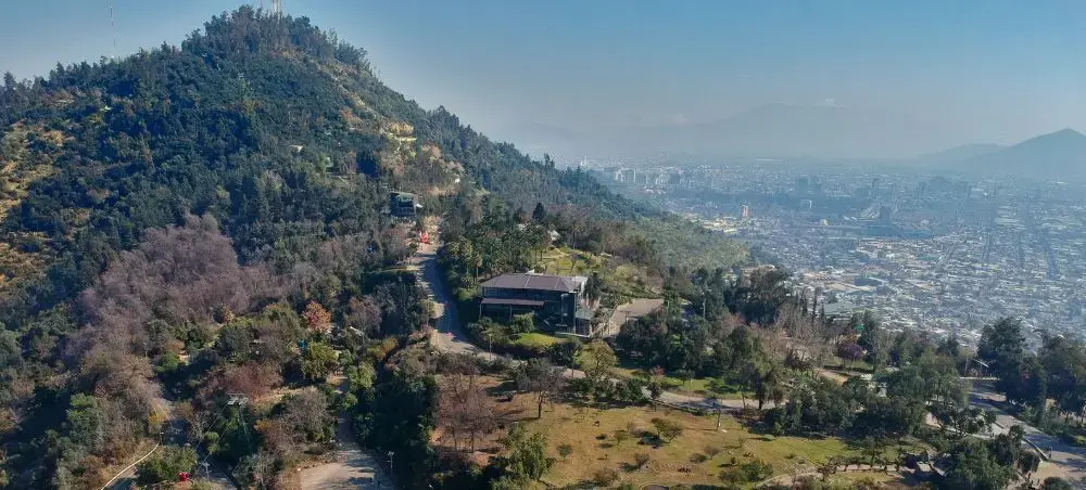 Aerial view of Santiago's hillside neighborhoods with luxury homes nestled among forested mountains