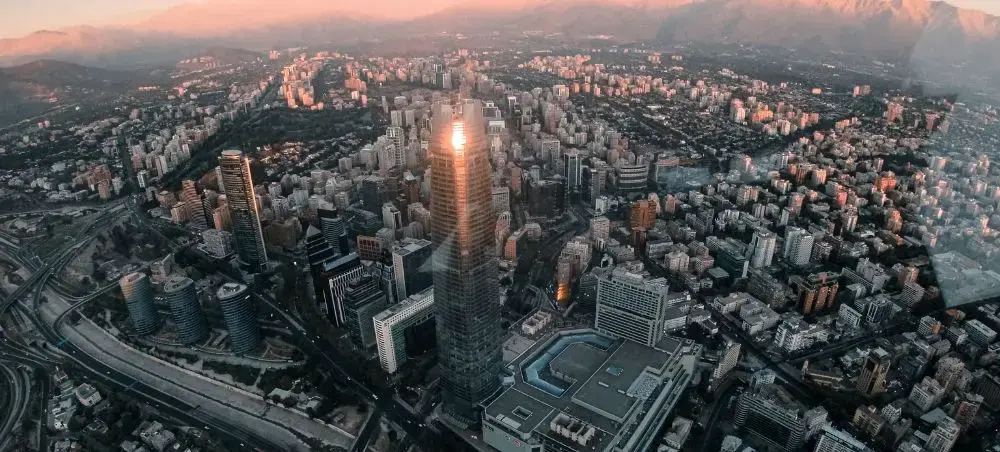 Aerial view of Santiago's modern skyline at sunset with Andes Mountains backdrop showcasing Chile's capital