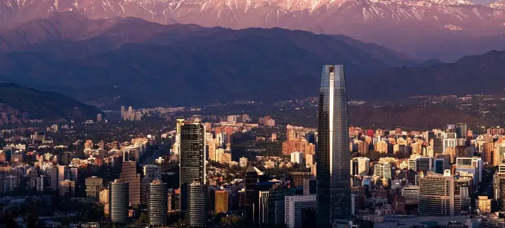 Santiago skyline at golden hour with snow-capped Andes mountains creating dramatic backdrop for Chile's capital