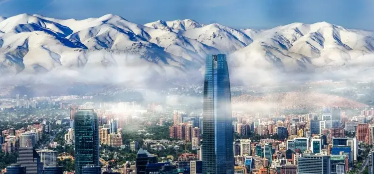 Santiago skyline with modern skyscrapers and snow-capped Andes mountains creating dramatic backdrop