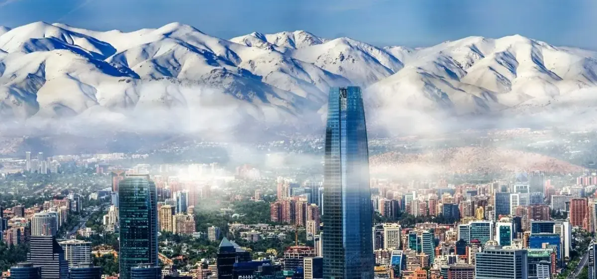 Santiago skyline with modern skyscrapers and snow-capped Andes mountains creating dramatic backdrop for Chile