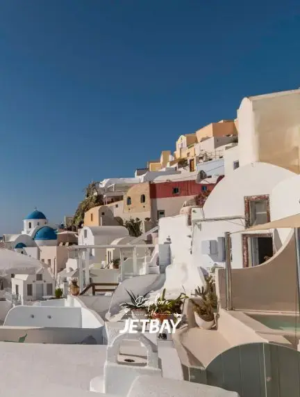 Iconic white-washed buildings and blue domes cascading down clifftops in Santorini's picturesque Oia village