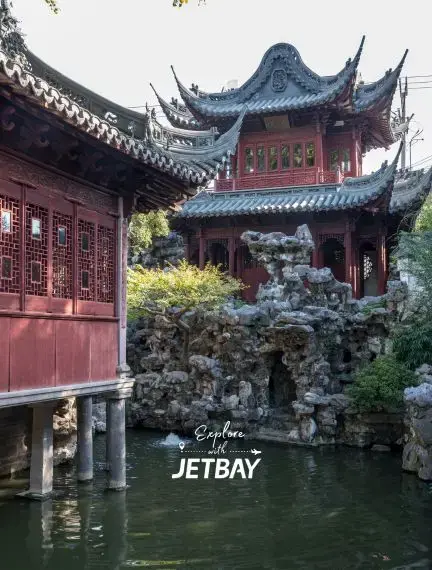Traditional Chinese pagoda and pavilion with ornate roofing overlooking tranquil water garden in Shanghai