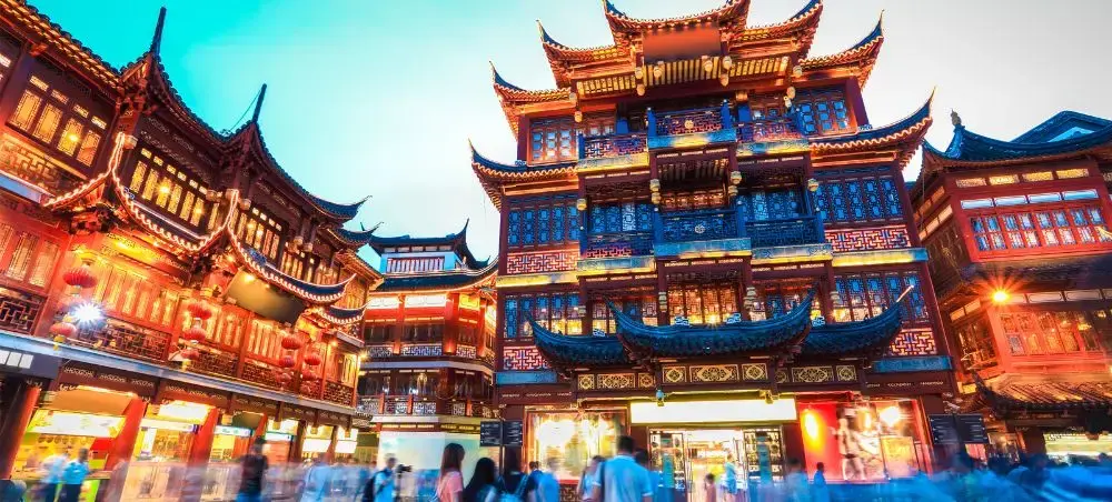 Traditional Chinese architecture illuminated at night in Shanghai's historic Yu Garden bazaar district