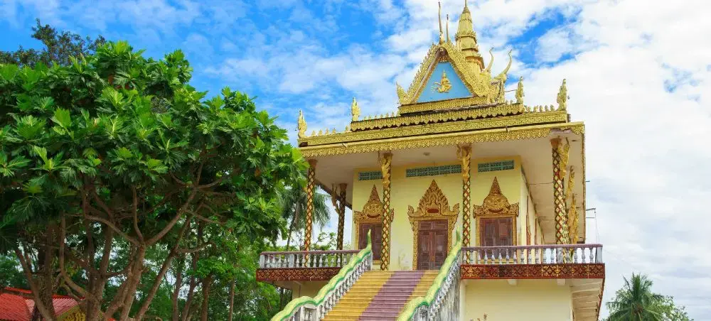 Traditional Cambodian Buddhist temple with golden ornate architecture and colorful stairs in Sihanoukville