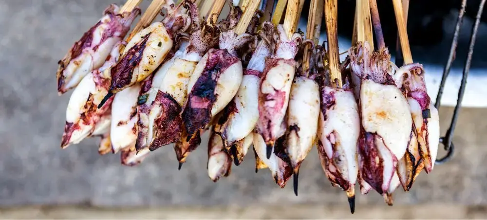 Fresh grilled squid skewers at Sihanoukville seaside market showcasing Cambodia's coastal culinary delights