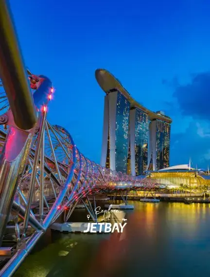 Singapore's illuminated Marina Bay Sands and Helix Bridge create stunning waterfront views for luxury travelers