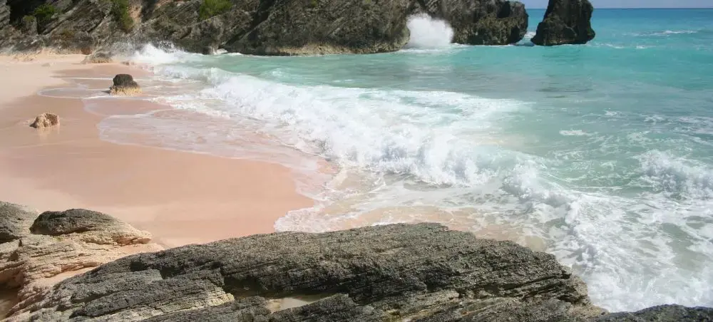 Pristine pink sand beach in Southampton, Bermuda with turquoise waters and dramatic limestone cliffs
