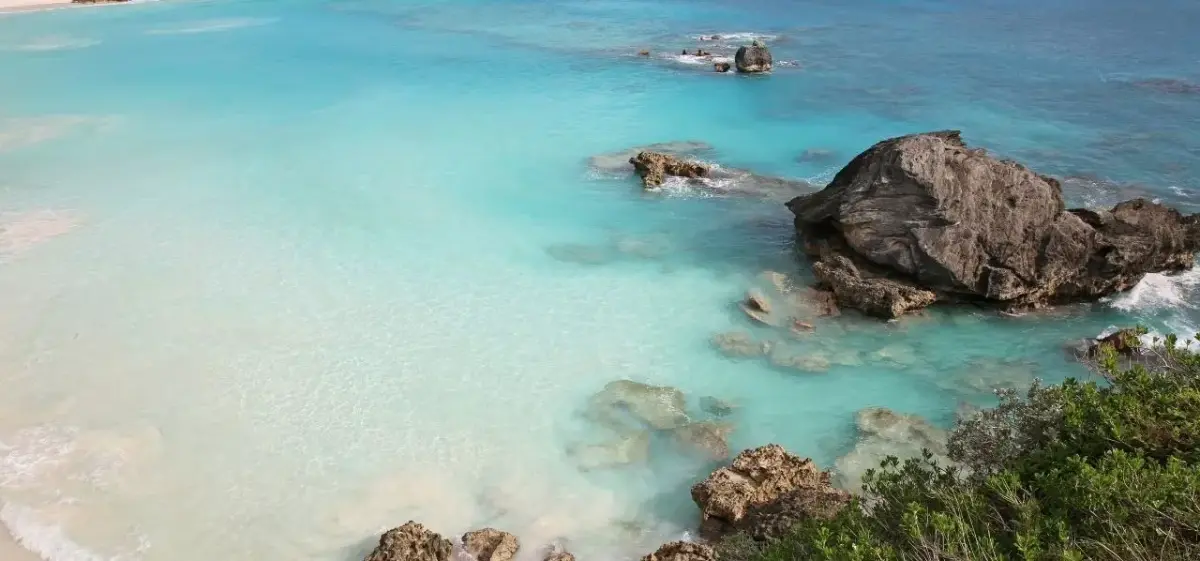 Crystal clear turquoise waters and pink sand beach with dramatic rock formations in Southampton, Bermuda