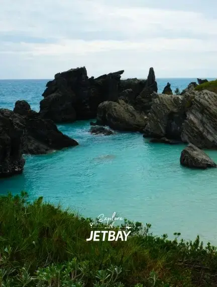 Turquoise waters flow between dramatic black volcanic rock formations at Horseshoe Bay Beach in Southampton, Bermuda