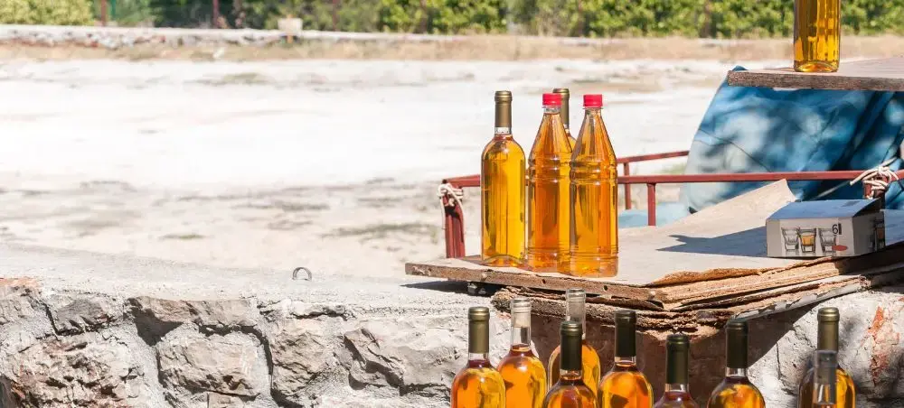 Premium Croatian spirits and local beverages displayed on rustic wooden table overlooking Split coastline