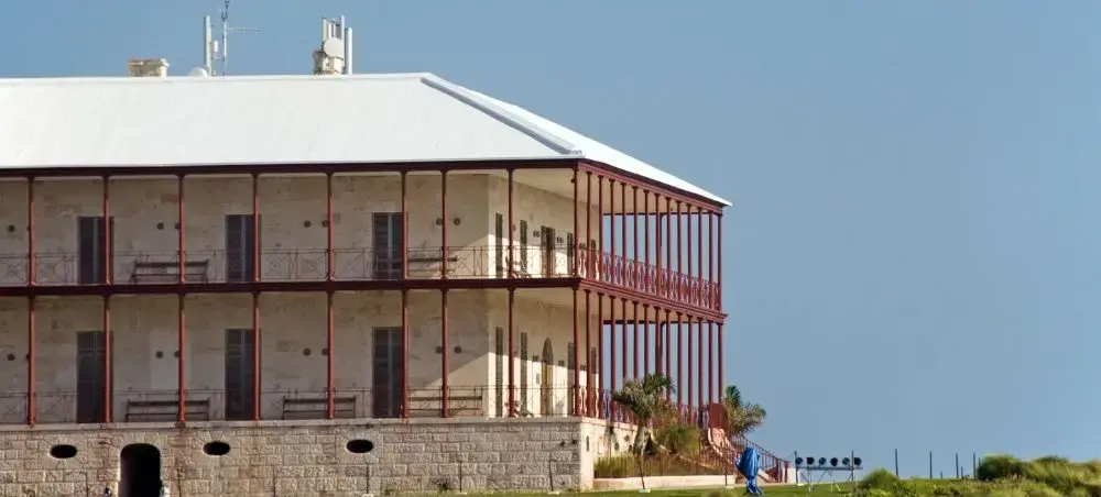 Historic colonial building with red balconies and white roof in St Georges, Bermuda's UNESCO heritage town