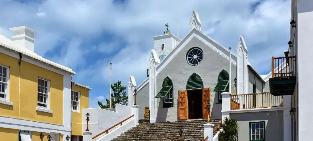 Historic white church with green shutters and stone steps in St Georges, Bermuda's colonial town center