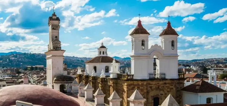 Historic colonial cathedral towers and bell tower overlooking Sucre's white-washed cityscape in Bolivia